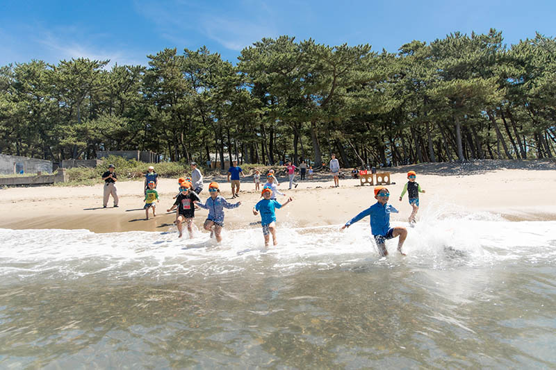 海水浴で浜辺を走る子どもたちの様子