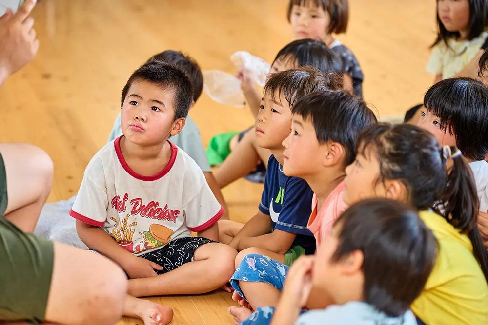 誕生日会で職員の出し物を楽しむ子どもたちの様子
